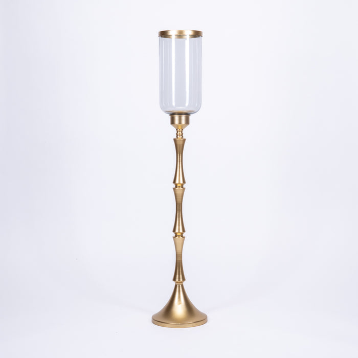 Porta candela Oro 39X15X74 CM. Complemento d'arredo dallo stile raffinato, dotato di vetro contenitore e base dal fondo largo in metallo, così da assicurare alla candela maggior equilibrio e stabilità. In vendita sullo shop di Silani.
