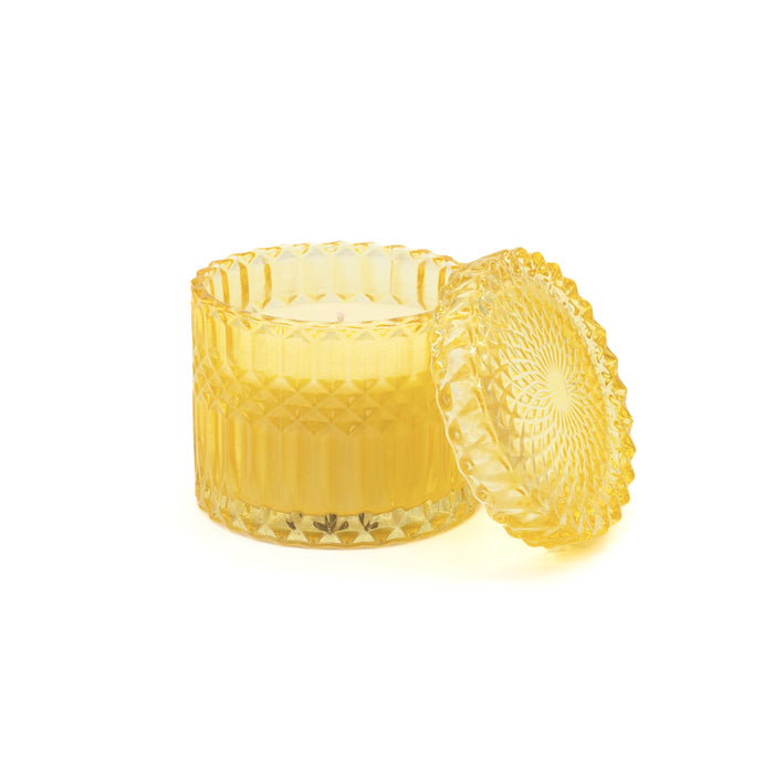 Candela di cera in bicchiere giallo