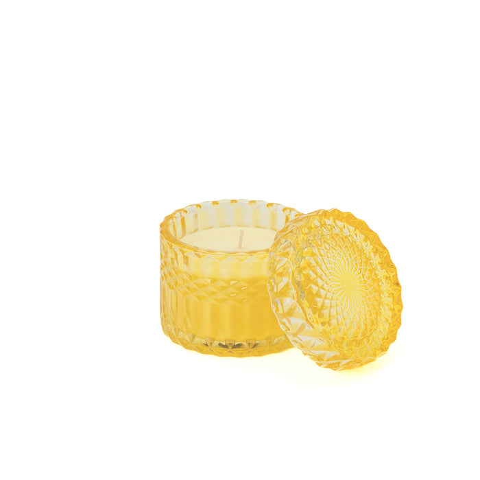 Candela di cera in bicchiere giallo