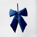 Fiocco in velluto blu di dimensioni 27x34cm. Grazie al gancio, può essere utilizzato come addobbo per albero di Natale, fuori porta, decorazione per feste ed eventi, ferma busta, segnaposto, bomboniera. In vendita sullo shop di Silani.